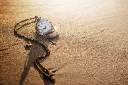 Vintage pocket watch on golden sand beach during sunrise or sunset in summer, Time concept